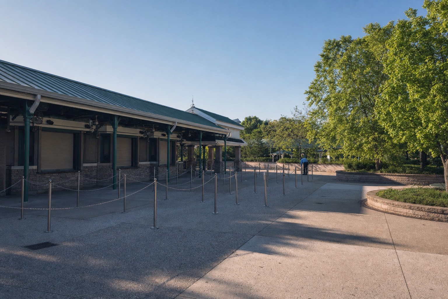 A nearly empty ticket plaza just after opening on a summer morning, barriers up but no queue in them