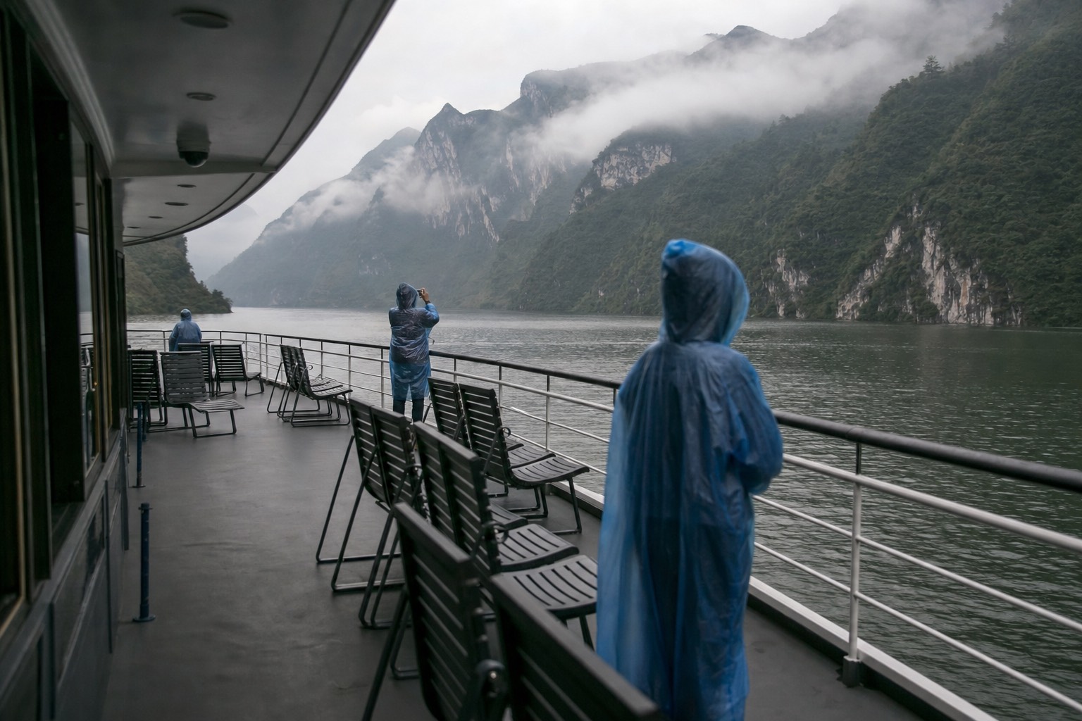 A half-empty boat deck on the first morning sailing, a handful of passengers choosing rail positions at leisure